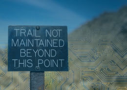 Sign reads 'Trail not maintained beyond this point' against a blue, circuit-pattern background (warning that the trail ends).